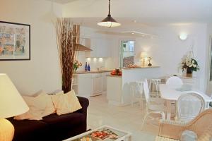 sala de estar y cocina con sofá y mesa en Lagrange Vacances - Eden Parc Golf, en Lacanau-Océan