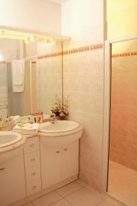 a bathroom with two sinks and a shower at Lagrange Vacances - Eden Parc Golf in Lacanau-Océan