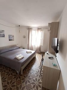 a bedroom with a bed and a television in it at casa ANNA in Trapani
