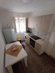 a kitchen with a sink and a refrigerator and a table at casa ANNA in Trapani