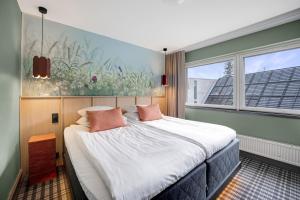 a bedroom with a large bed with pink pillows at Break Sokos Hotel Koli in Kolinkylä