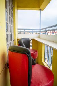 - deux chaises rouges assises sur un balcon dans l'établissement Lovely 1 Bedroom Fully Furnished Nakuru, à Nakuru