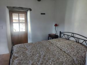 a bedroom with a bed and a window and a door at Les chambres de la Bastide in Saint-Sauveur-de-Montagut