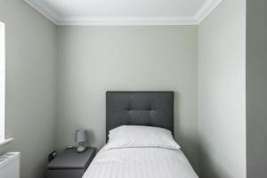 Dormitorio con cama y mesita de noche con lámpara en Gillian House - Charming Broadstairs apartment, en Kent