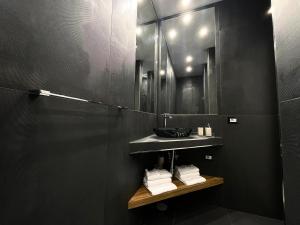 a bathroom with a sink and a mirror and towels at Aroma Apartment, Maschio Angioino-Porto Di Napoli in Naples