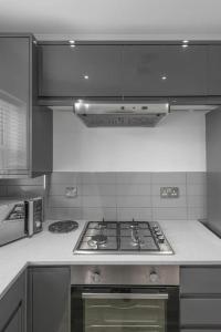 a kitchen with a stove top oven in a kitchen at Gillian House - Charming Broadstairs apartment in Kent