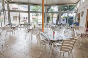 a restaurant with white tables and chairs and windows at HI Hostel Dubrovnik in Dubrovnik