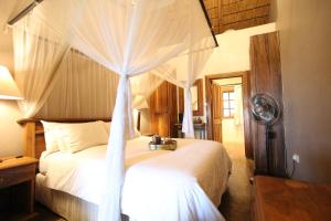 a bedroom with a white bed with a canopy at Kumbali Country Lodge in Lilongwe