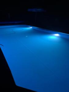 uma luz azul no chão num quarto escuro em Willa 250 M z basenem, jacuzzi, ogrodem , tarasem oraz 2 hektary sadu , kominek i inne atrakcje 
