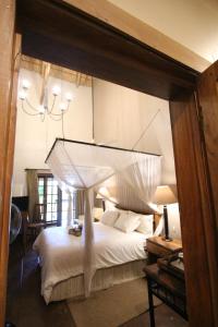 a bedroom with a large bed with a canopy at Kumbali Country Lodge in Lilongwe
