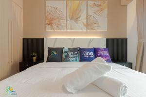1 dormitorio con cama blanca y almohadas en R&F Princess Cove @ UHA, en Johor Bahru