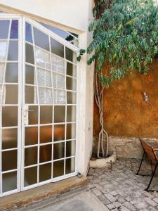 eine offene Tür mit einem Baum neben einem Gebäude in der Unterkunft Eins Art Studios in Omaruru