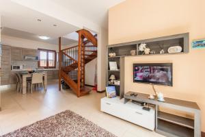 a living room with a television and a dining room at Getaway Npetto Gozitan Villa - Happy Rentals in Mġarr
