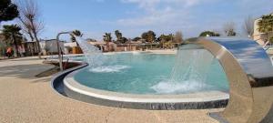 a fountain in a swimming pool in a park at Le Cosy, mobil-home 4-6 personnes au camping les Sables du Midi à Valras-Plage in Valras-Plage