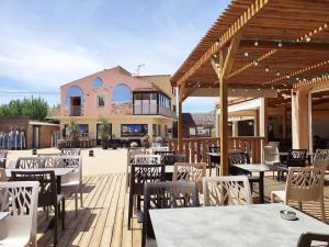 a restaurant with tables and chairs on a wooden deck at Le Cosy, mobil-home 4-6 personnes au camping les Sables du Midi à Valras-Plage in Valras-Plage