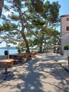 einen Gehweg mit Tischen und Stühlen neben dem Wasser in der Unterkunft Apartment Pomirenja in Korčula