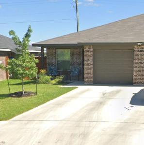 a house with a garage and a tree in the yard at Fully Furnished with Full Kitchen Appliances, 3 Bedroom and 2 Bath Home in Killeen