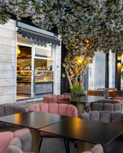 um restaurante com duas mesas, cadeiras e árvores em Aroma Apartment, Maschio Angioino-Porto Di Napoli em Nápoles