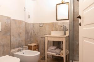bagno con lavandino, servizi igienici e specchio di Le Camere di Olivia a Ravenna