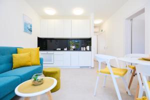ein Wohnzimmer mit einem blauen Sofa und einem Tisch in der Unterkunft Green Lantern apartments Okuklje in Okuklje