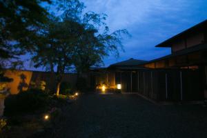 una casa con luces en el patio por la noche en Bettei Haruki en Beppu