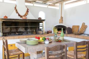 una cucina con tavolo, piatti e frutta di Villa Elena Loutraki a Loutraki