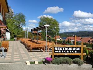 a restaurant with wooden benches and a sign that reads resistanceergy at Pension Vyhlídka in Přední Výtoň