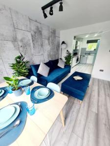 Una sala de estar con un sofá azul y una mesa. en Spacious 5bed house, FREE parking, NO PARTY !, en Glasgow