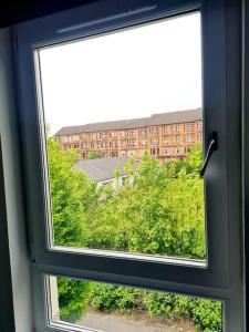 Una ventana abierta con vista a un edificio en Spacious 5bed house, FREE parking, NO PARTY !, en Glasgow
