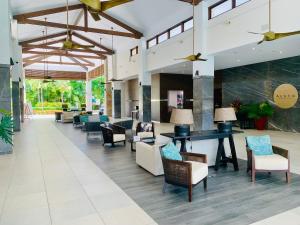 un vestíbulo abierto con sillas y mesa en Tropical Retreat - Poolside Swimout - Ground Floor - Sea Temple Resort & Spa Port Douglas en Port Douglas