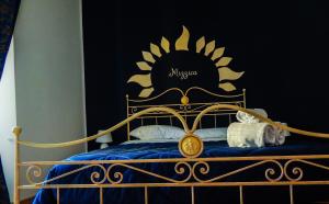 a bedroom with a bed with a black and gold headboard at Camurria in Piazza Armerina