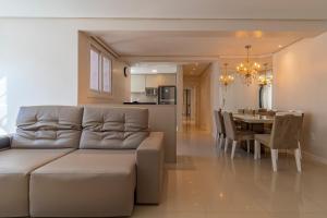 a living room and dining room with a couch and a table at Apto 4 dormitórios em Canela - @stayhousetemporada in Canela