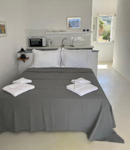 a bedroom with a bed with two towels on it at The Black Pig Studios in Posidhonía