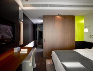 a hotel room with a bed and a tv at The Met Hotel Thessaloniki, a Member of Design Hotels in Thessaloniki