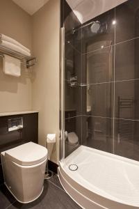 uma casa de banho com um WC e uma cabina de duche em vidro. em Coldra Court Hotel by Celtic Manor em Newport