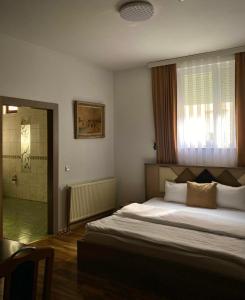 Golden BnB Hotel في بريشتيني: غرفة نوم مع سرير كبير ودش
