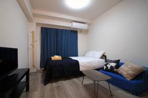 SG LION HOUSE 2P Free pocket Wi-fi! في طوكيو: غرفة نوم بسرير واريكة زرقاء