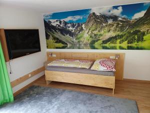 1 dormitorio con un mural de montañas en la pared en Ferienwohnung Luxner, en Hopfgarten im Brixental