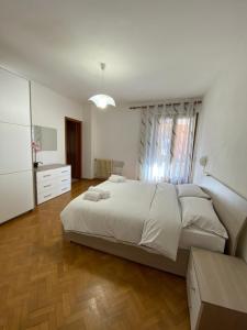 a bedroom with a large white bed and a wooden floor at Casa Ahmati Borgo Vesio in Tremosine Sul Garda