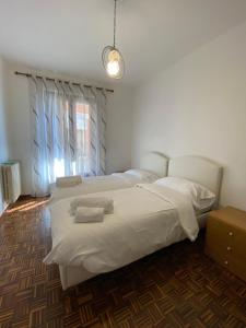 a bedroom with two white beds and a window at Casa Ahmati Borgo Vesio in Tremosine Sul Garda