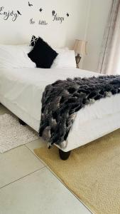 Un dormitorio con una cama con una manta de animal negro. en La Lucia Sleepover, en Durban