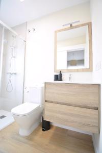 uma casa de banho com um WC, um lavatório e um espelho. em Apartamento Aires de Lavanda em Sanxenxo