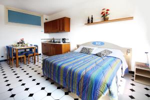 a bedroom with a bed and a kitchen with a table at Residence Hotel Edy in Imperia