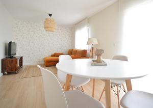 uma sala de estar com uma mesa branca e cadeiras em Apartamento Aires de Lavanda em Sanxenxo