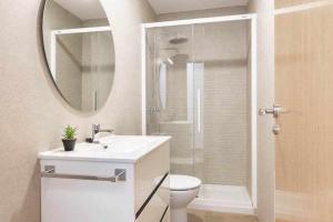 a bathroom with a sink and a toilet and a mirror at Apartamentos El Mirador in Villarroya de los Pinares +24 photos