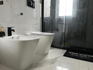 a bathroom with a toilet and a sink and a shower at Maison Chanel in Milan