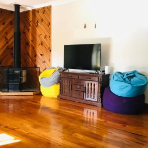 a living room with a flat screen tv and two bean bags at Northern Holiday Cottage in Whangarei