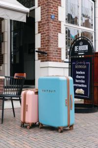 two pieces of luggage sitting on a sidewalk in front of a building at Hotel De Kroon Gennep in Gennep