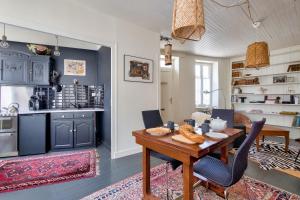 a kitchen and dining room with a wooden table and chairs at Jolie maison pour 4, aux portes de St Martin de Ré in Saint-Martin-de-Ré