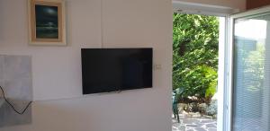 Apartments LAGUNA 20, 20A في إيزولا: تلفزيون بشاشة مسطحة على جدار بجوار نافذة